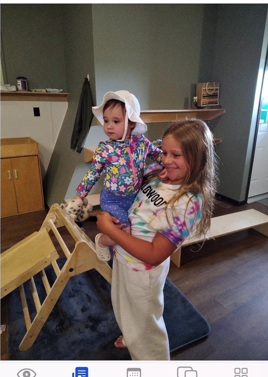 An older child carrying a toddler on their hip