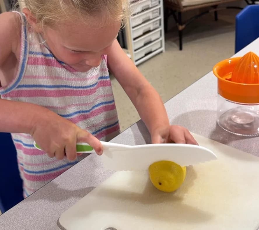 A child slicing a lemon in a practical life lesson